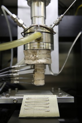 A differenza di altre tecniche di stampa metalli 3D che utilizzano laser per fondere la polvere di metallo, l'approccio scrittura metallo diretto incorpora un grezzo che viene scaldata fino a raggiungere uno stato semi-solido prima di essere forzata attraverso un ugello. Durante il raffreddamento, il materiale indurisce per formare una struttura metallica 3D.